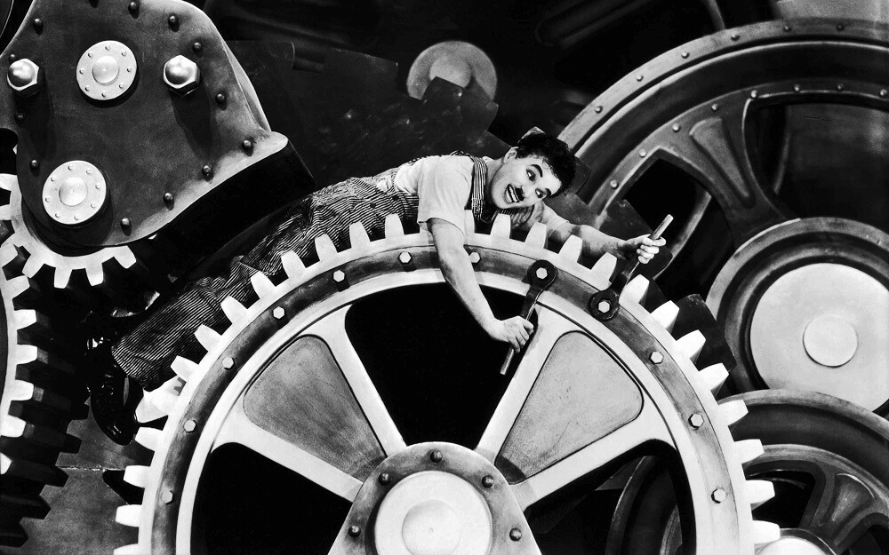 Hacks-for-better-backlogging-stock-chaplin-modern-times Charlie Chaplin on big tech wheel in black and white