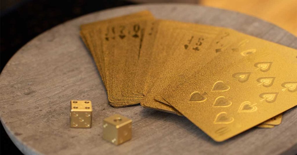 Strategy + OKRS Part 1: The golden ingredients in your product roadmap Golden playing cards and dice on table