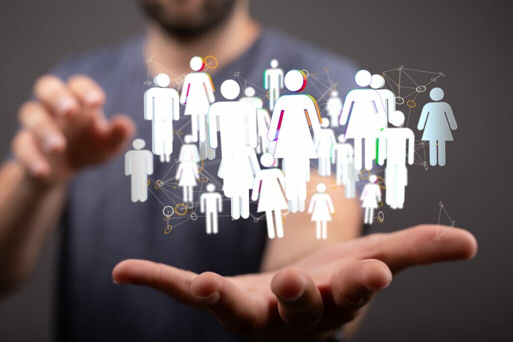 A,Person,Presenting,The,Virtual,Projection,Of,Digital,Conference,Teamwork Man holding out his hands with stick figure people floating on it